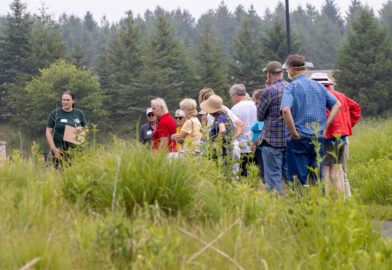 CLCF staff member leading a group through the prairie